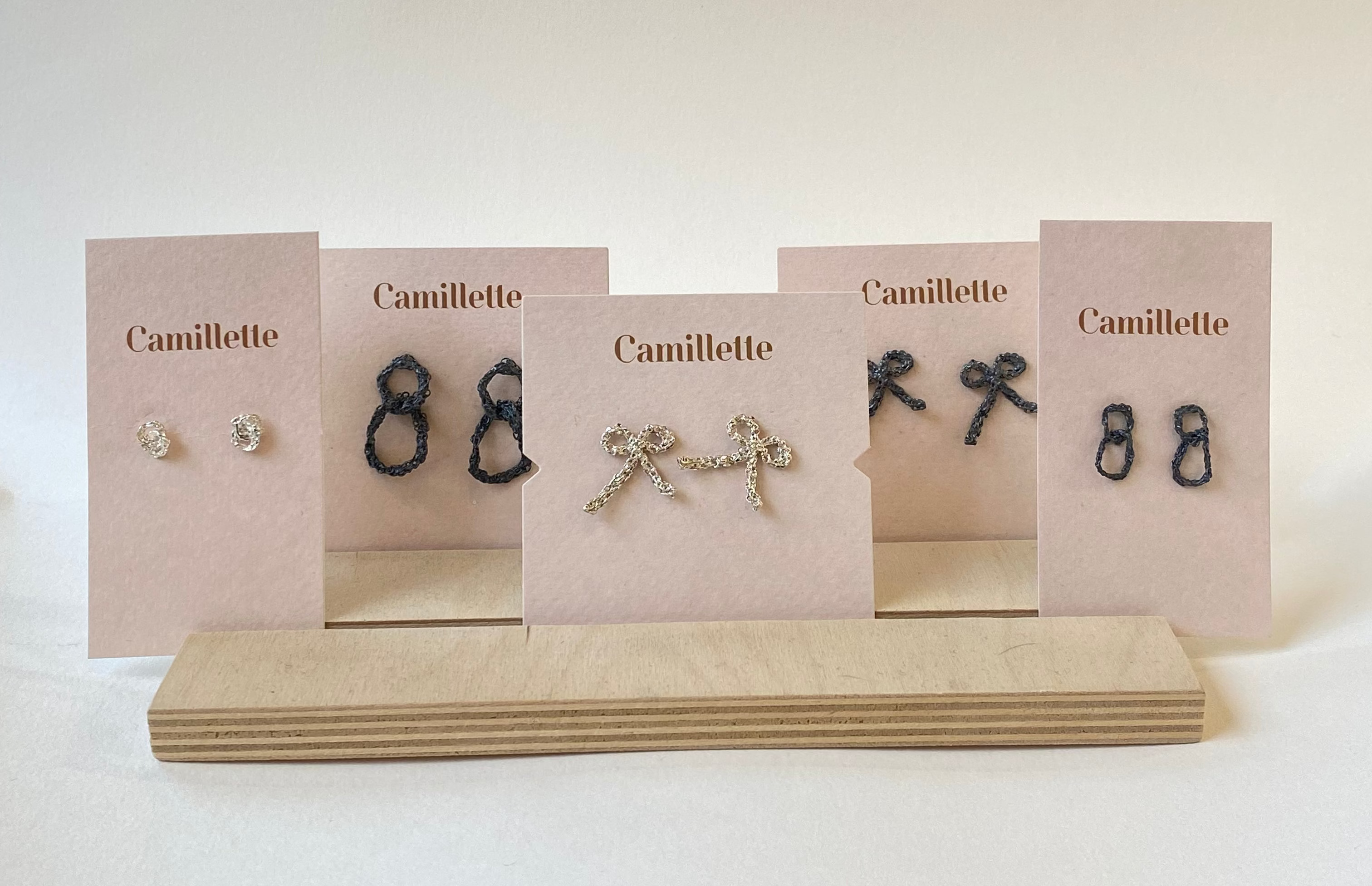 Set of Camillette earrings on display with branded cards on a white background
