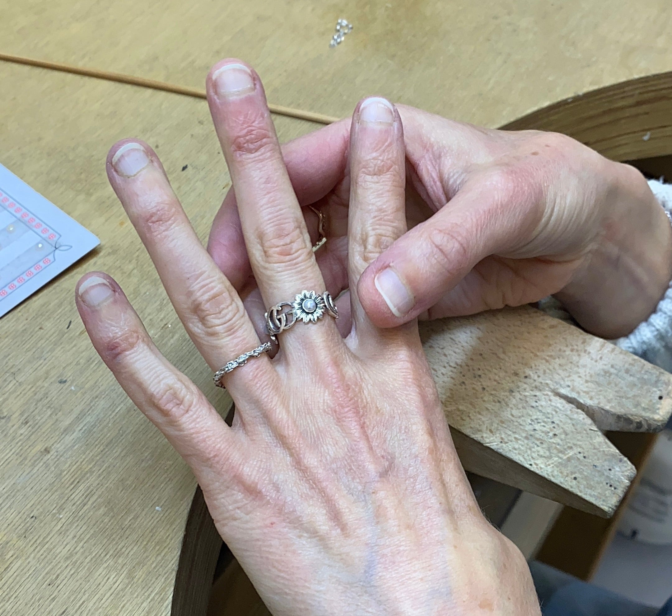 Person wearing a ring on a wooden surface