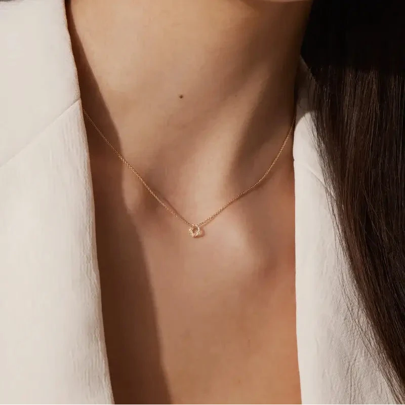 Close-up of a woman wearing a delicate gold necklace and earring.